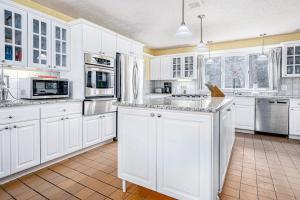 a large white kitchen with white cabinets and appliances at Birdie Bungalow in Saugatuck