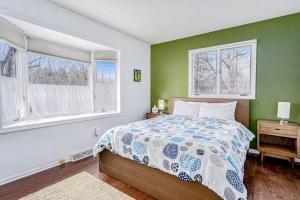 a bedroom with a bed and two windows at Birdie Bungalow in Saugatuck +11 photos