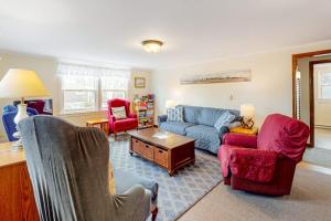 a living room with a blue couch and red chairs at Nauset Beach Dream in Orleans