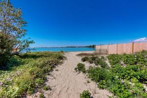 a sandy path to the beach with the ocean in the background at Bayview Bliss in West Yarmouth