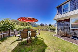 a table and chairs with an umbrella in the yard at Bayview Bliss in West Yarmouth
