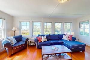 a living room with two blue couches and a table at Bayview Bliss in West Yarmouth +34 photos
