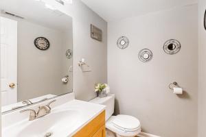 a bathroom with a sink and a toilet and a mirror at Seafarer 7 in Ocean Pines