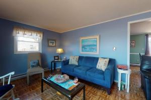 a living room with a blue couch and a table at Summer Get Away in Dennis Port
