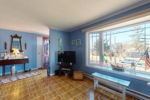 a living room with blue walls and a large window at Summer Get Away in Dennis Port
