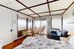 a bedroom with a bed and a couch and a table at The Pagoda Perch in North Truro