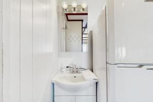 a white bathroom with a sink and a refrigerator at The Pagoda Perch in North Truro +8 photos