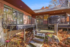 a house with a deck and stairs in front of it at Tally-Sun on the Bluff in Harbor Springs
