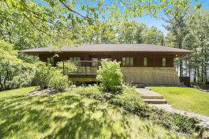 a large house with a porch in a yard at Tally-Sun on the Bluff in Harbor Springs