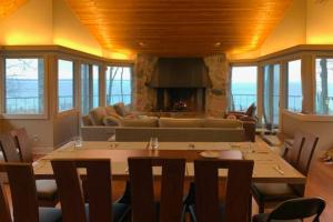 a living room with a table and a fireplace at Tally-Sun on the Bluff in Harbor Springs