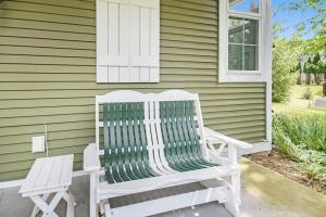 a white rocking chair sitting outside of a house at Appy Place in South Haven +34 photos
