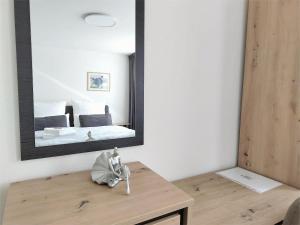 a bedroom with a mirror and a table with a bed at Casa Rheinblick - Apartment C in Basel