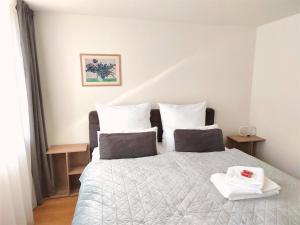 a bedroom with a bed with two towels on it at Casa Rheinblick - Apartment C in Basel