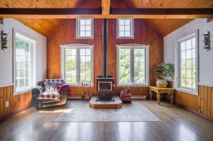 a living room with a fireplace and a couch at Le rocher - St-Adolphe in Saint Adolphe D'Howard