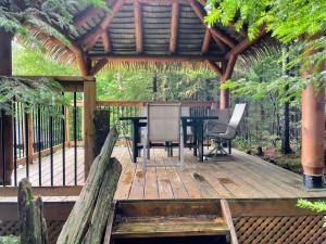 a wooden deck with a table and chairs on it at Le rocher - St-Adolphe in Saint Adolphe D'Howard