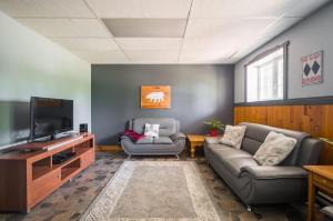 a living room with two couches and a flat screen tv at Le rocher - St-Adolphe in Saint Adolphe D'Howard +30 photos