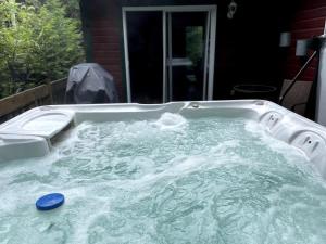 a jacuzzi tub in the backyard of a house at Le rocher - St-Adolphe in Saint Adolphe D'Howard