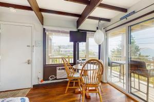 a dining room with a table and chairs and a balcony at Seashore Escape in North Truro