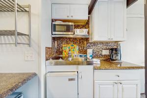 a kitchen with a sink and a microwave at Seashore Escape in North Truro