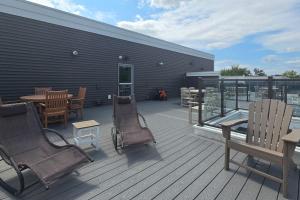 a deck with chairs and tables on a building at Cozy TC Bay Condo in Traverse City