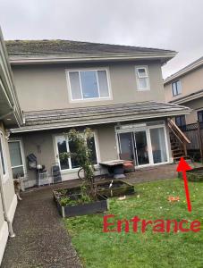 a house with a red arrow pointing to an entrance at A quiet independent entrance suite on second floors with private bathroom close to YVR in Richmond