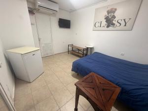 a bedroom with a bed and a table in it at ברזיליאנו - Braziliano in Eilat