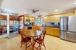a kitchen with a table and a stainless steel refrigerator at Absolute Leelanau in Glen Arbor