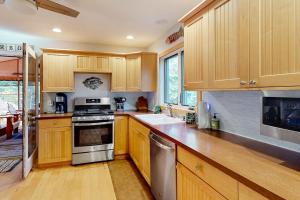 a kitchen with wooden cabinets and stainless steel appliances at Absolute Leelanau in Glen Arbor +10 photos