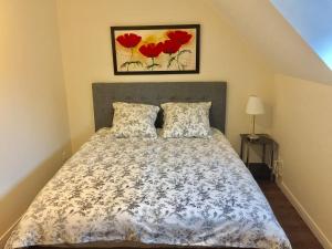 ein Schlafzimmer mit einem Bett mit roten Blumen darauf in der Unterkunft Grande Rue House Disneyland Paris in Magny-le-Hongre