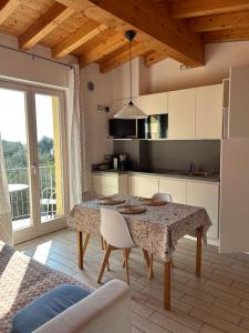 a kitchen with a table with chairs and a table at Villa Gaia Apartments pool wifi parking in Malcesine
