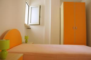 a bedroom with a bed and an orange cabinet at Appartamento Roberti in Corsano