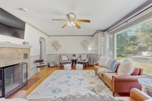 a living room with a ceiling fan and a fireplace at Charlotte’s Chateau in New Buffalo