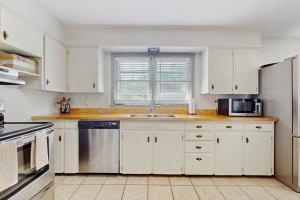 a kitchen with white cabinets and a stainless steel dishwasher at Charlotte’s Chateau in New Buffalo +18 photos