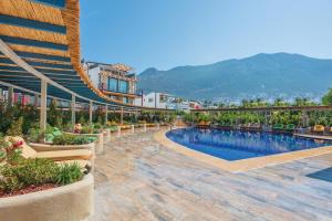 a resort with a swimming pool and mountains in the background at Asfiya Loft Apartments in Kalkan