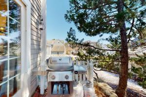 a grill sitting on a porch next to a window at Maushop Village Beach Getaway in Mashpee