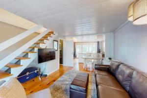 a living room with a couch and a staircase at Maushop Village Beach Getaway in Mashpee