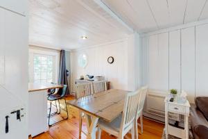 a dining room with a wooden table and chairs at Maushop Village Beach Getaway in Mashpee +15 photos