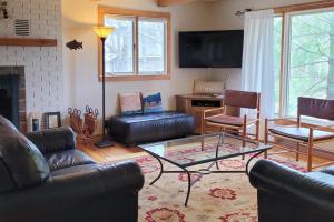 a living room with leather furniture and a tv at Hal-Sea-On House in Glen Arbor