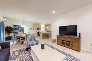 a living room with a flat screen tv on a wooden entertainment center at Oak Bluffs Beauty in Oak Bluffs