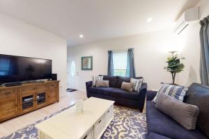 a living room with a couch and a tv at Oak Bluffs Beauty in Oak Bluffs