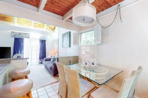 ein Wohnzimmer mit einem Glastisch und Stühlen in der Unterkunft Summersea in Mashpee