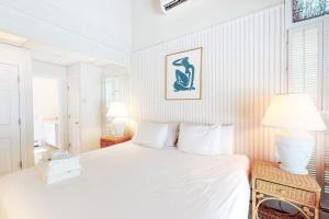 ein weißes Schlafzimmer mit Bett und Lampe in der Unterkunft Summersea in Mashpee + 20 Fotos