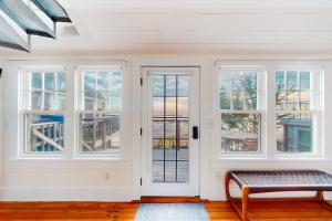 a room with white walls and windows and a bench at The Lighthouse in Provincetown