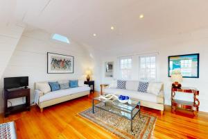 a living room with two white couches and a television at The Lighthouse in Provincetown