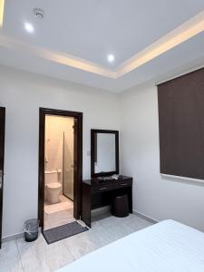 a bedroom with a bed and a mirror and a bathroom at بستان الورد 2 in Taif