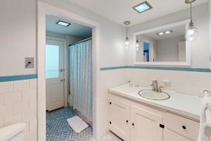 a white bathroom with a sink and a mirror at West Dennis Dockside in West Dennis