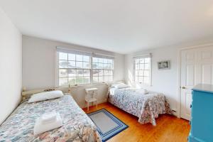 a bedroom with two beds and two windows at West Dennis Dockside in West Dennis