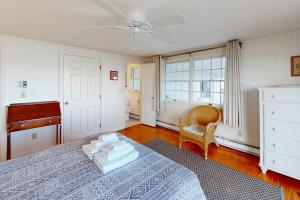 a bedroom with a bed and a dresser and a piano at West Dennis Dockside in West Dennis +13 photos