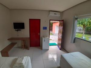 a room with a red door and a table and a refrigerator at Torre do Sol Park Hotel in Chapadinha