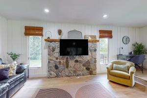a living room with a stone fireplace with a tv at Minutes from it All in Petoskey